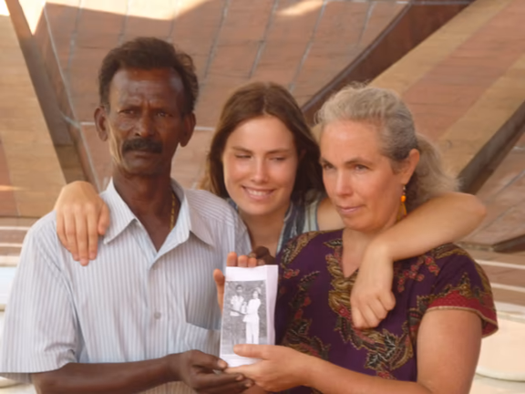 Ramalingam and Marta, embraced by Marta’s daughter Marina, holding the photo when they, as children, laid the inauguration stone of the Matrimandir
