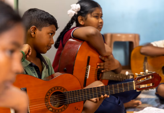 Village children practising the guitar