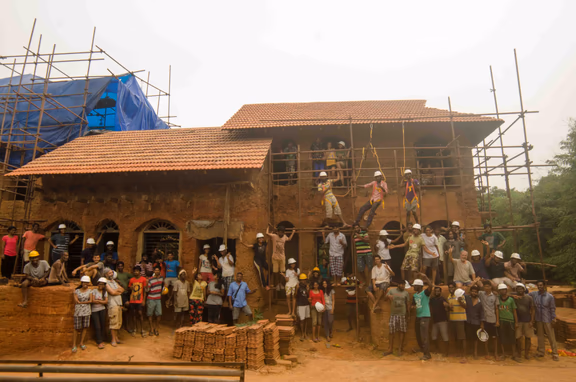 The three prototype buildings of Sacred Croves, with the Sacred Groves' team