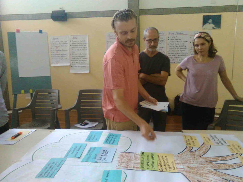 Angelo prepares an FAMC meeting, Lyle and Auralice look on