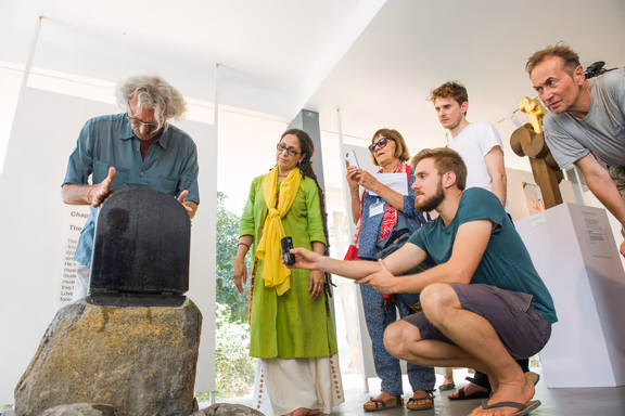 Trying the Svaram singing stone at the Lila-CIRHU exhibition in the Citadines Centre d'Art