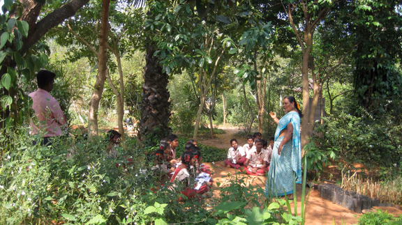 A group of school children in the herbal garden with Kaamachi, one of the educators at the Botanical Gardens